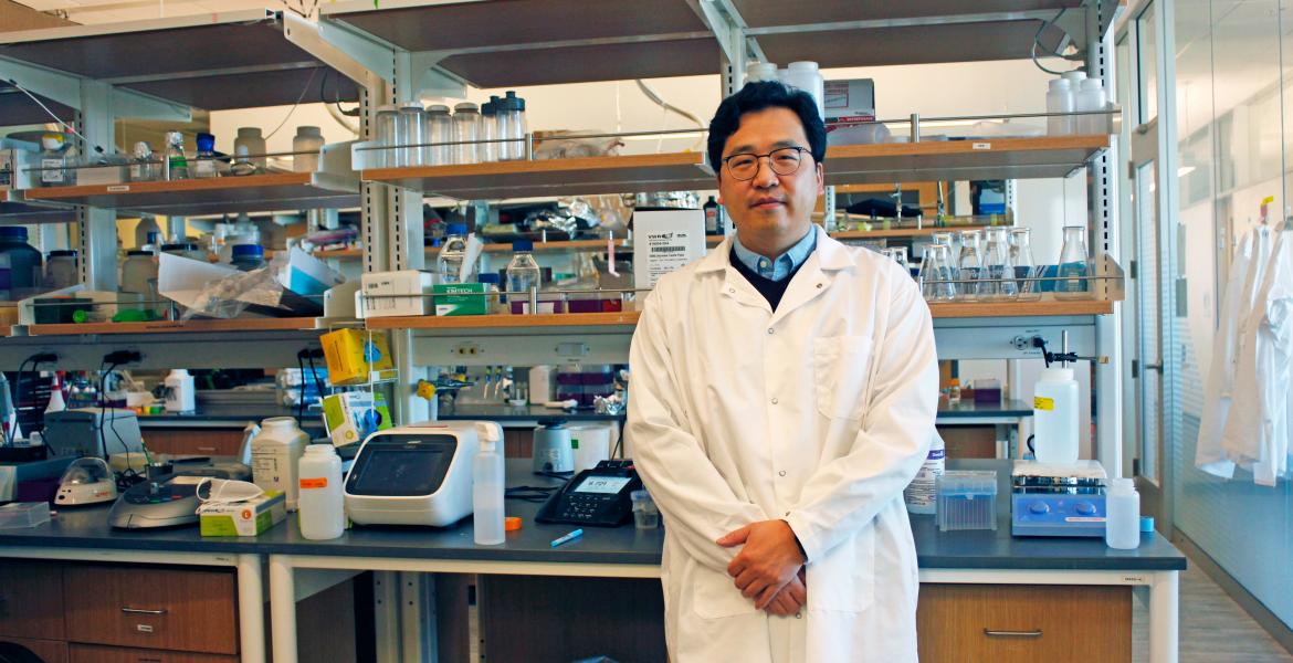 Minkyu Kim in a white lab coat in his laboratory