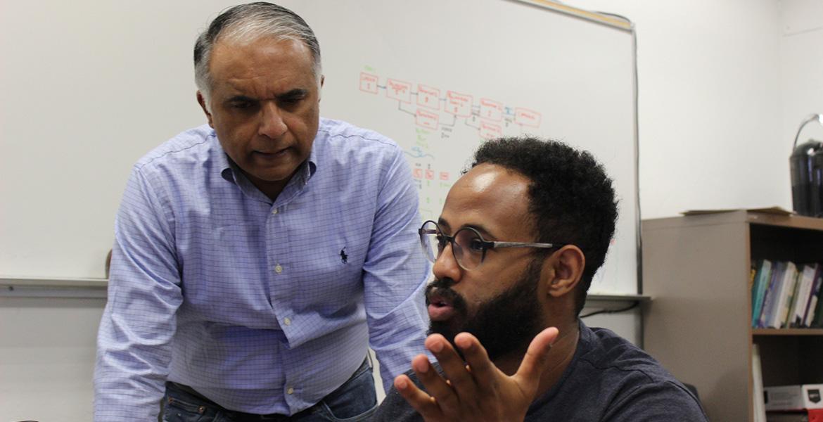 Two people speak in a classroom