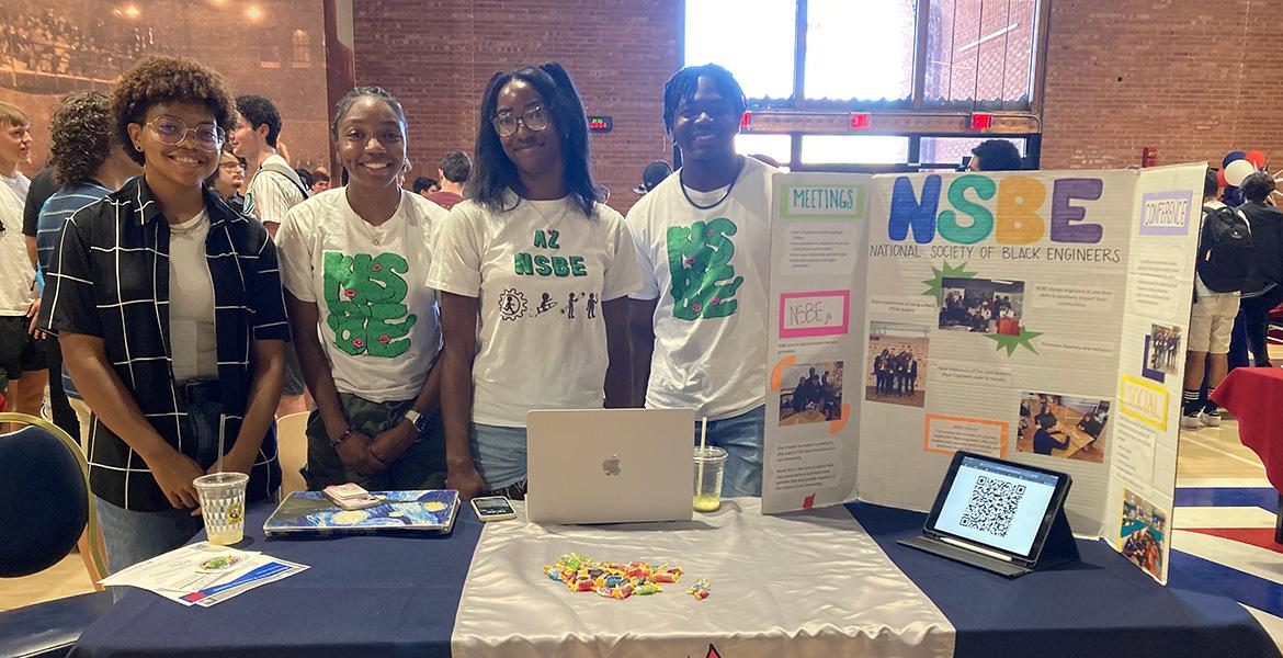 Four students pose for a photo at a student event.