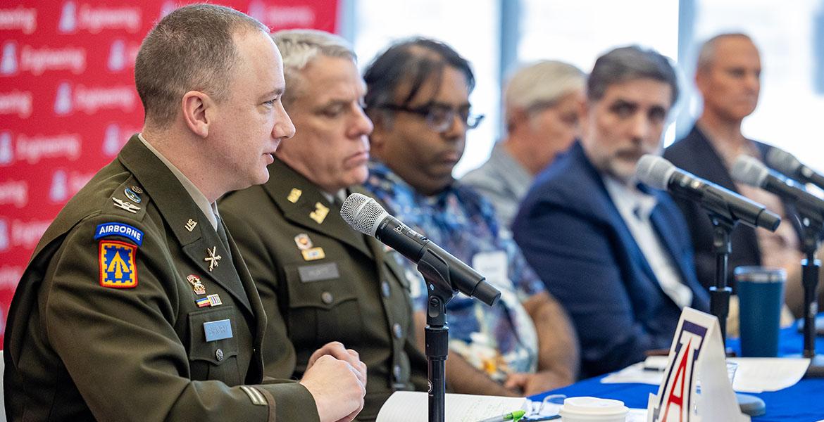 conference panelists sit at a table