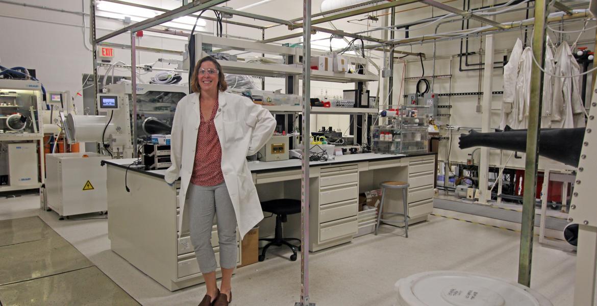Erin Ratcliff in her lab, wearing a lab coat.
