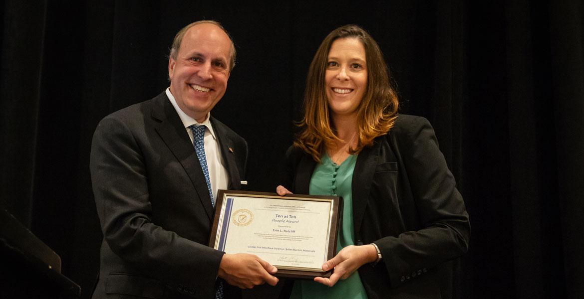 Erin Ratcliff receives a framed certificate from Department of Energy Under Secretary for Science Paul Dabber
