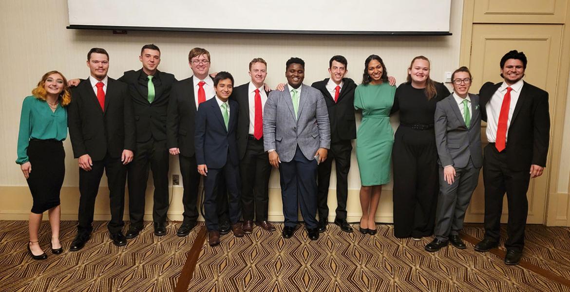 A row of about 12 people posing for a photo.