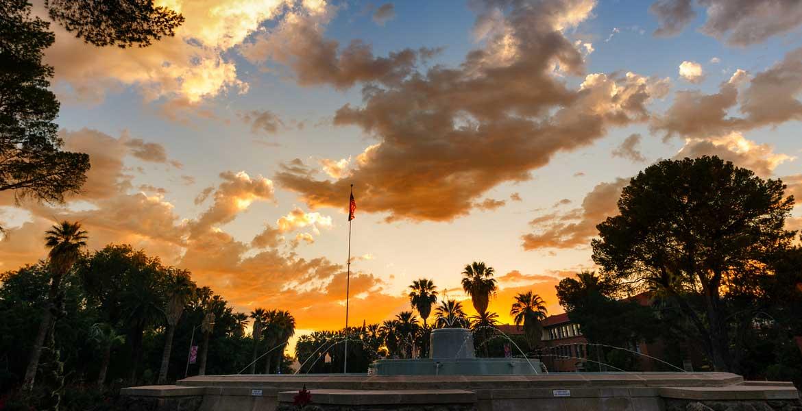 The sun sets over a fountain on the UA campus.