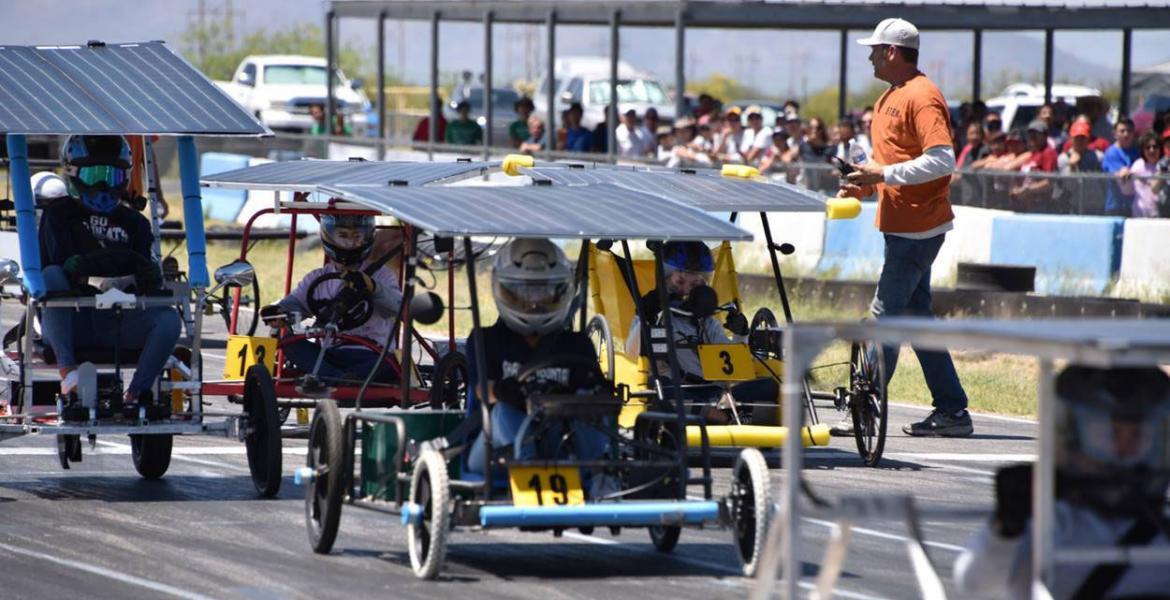 Students in solar-powered go-karts get ready at the starting line of a race.
