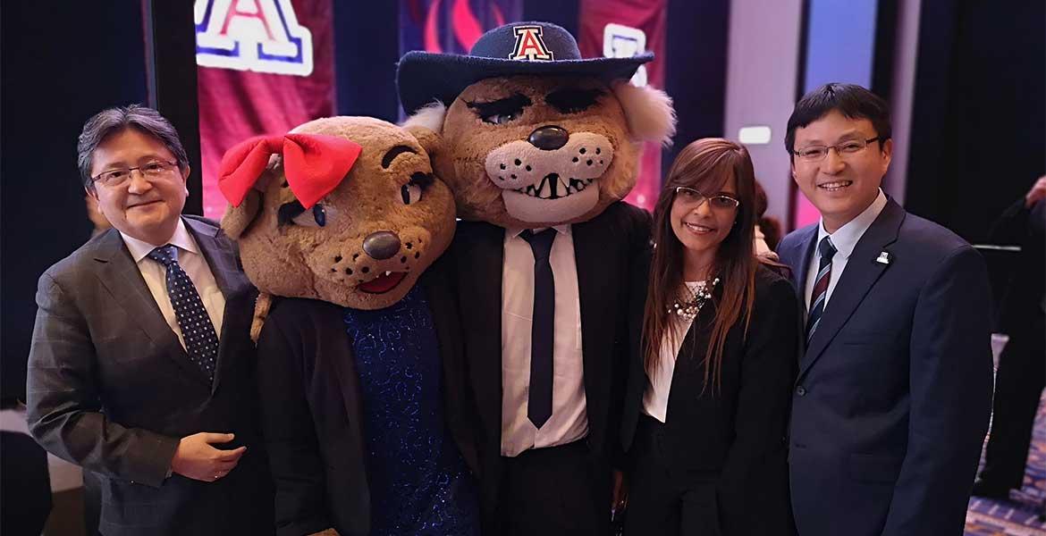 Two men and a woman pose for a photo with Wilma and Wilbur Wildcat