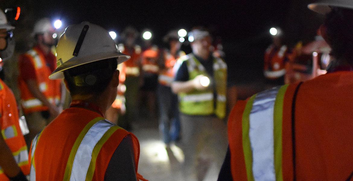 a group of students tour a dark mine