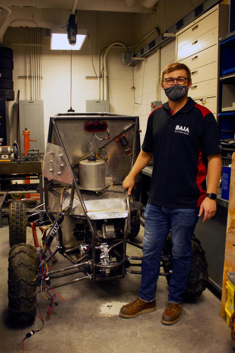 Erik Knowles next to the Baja SAE vehicle