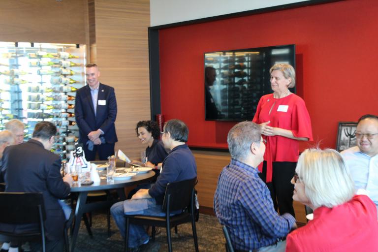 Liesl Folks and Mark Van Dyke stand and speak to the group.