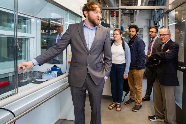 Biomedical engineering assistant professor Philipp Gutruf shows a group some of the lab's equipment.