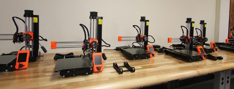 several 3D printers on a table