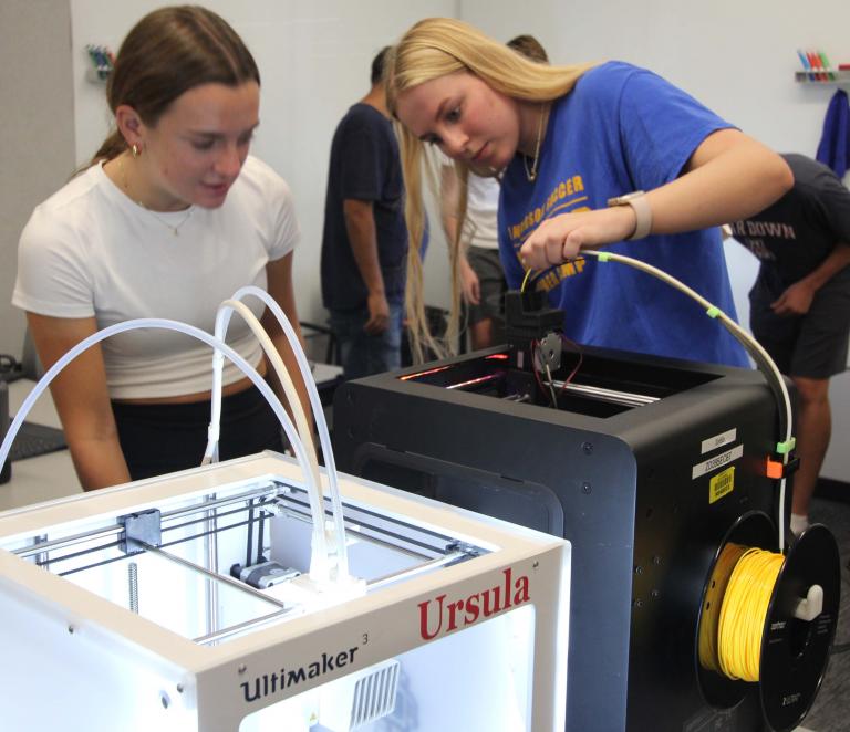 Two students use a 3D printer