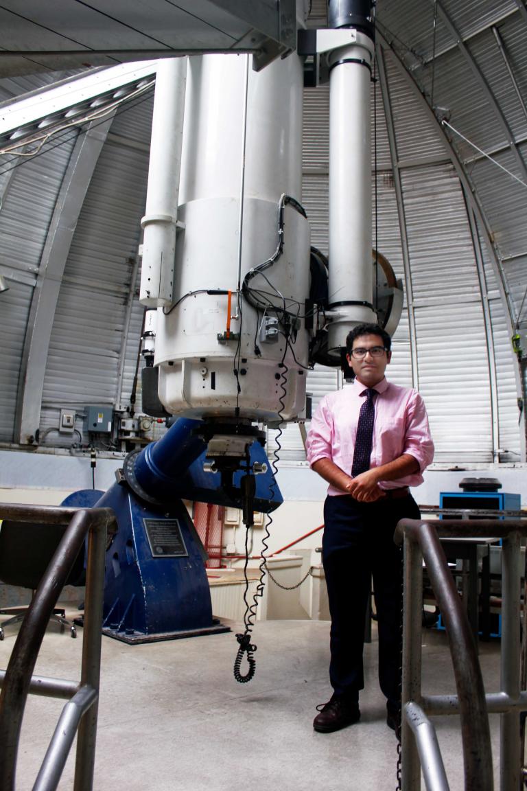 Arash Roshanineshat in front of the Steward Observatory's enormous telescope.