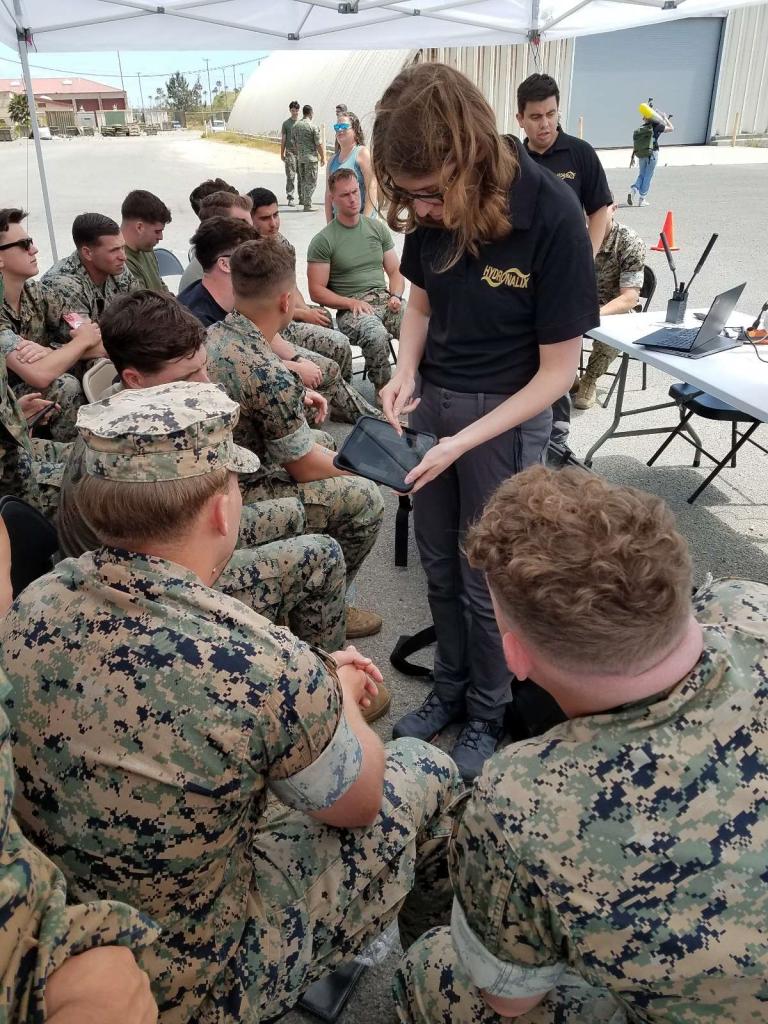 Two people train Marines in an outdoor classroom