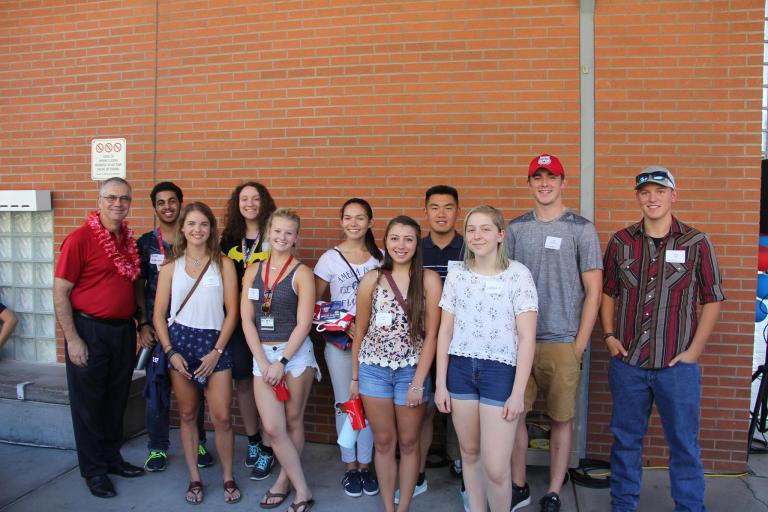 Jeff Goldberg and a group of smiling students in front of a brick wall.