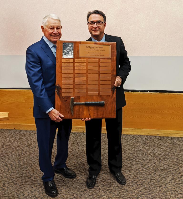 Richard Adkerson and Moe Momayez holding a large plaque engraved with a series of names