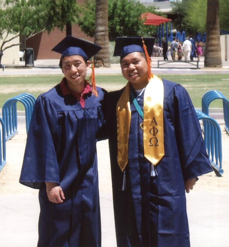 Ted and Chris Hom pose in graduaton caps and gowns at the University of Arizona campus