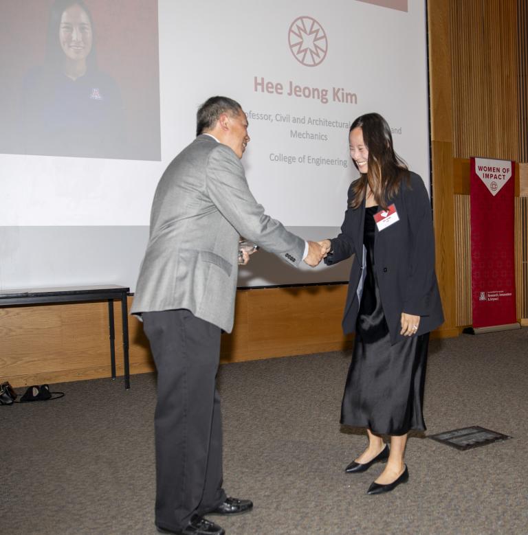 Kim shakes hands with the award presenter