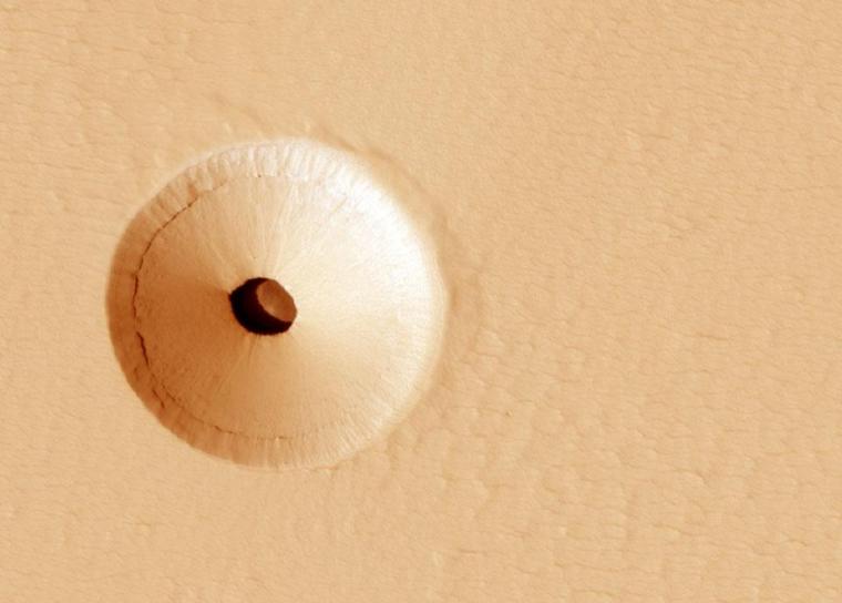 A hole in the surface of Mars, spotted by the HiRISE camera, reveals a cave below. 