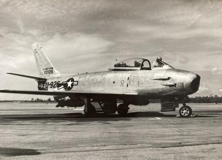 a black and white photo of an F-86 fighter jet