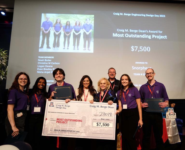 8 people pose with an oversized prize check