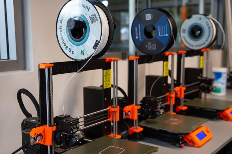 three 3D printers in a lab