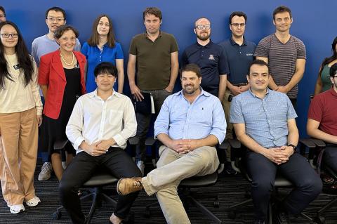 A group of instructors poses indoors, with one row sitting and one standing