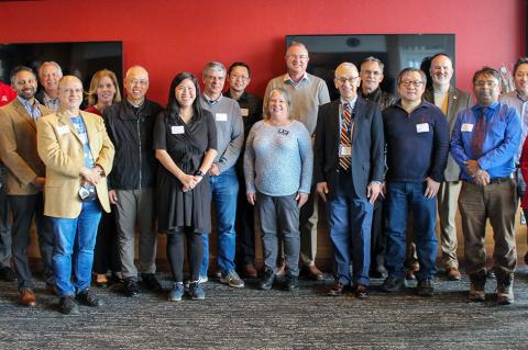 the large group of awardees stands together indoors