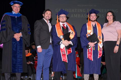 Five people stand on stage at the convocation ceremony