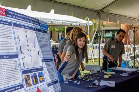 A group of students at an outdoor expo table