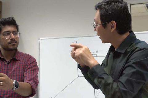 two faculty members work with radar equipment in a classroom