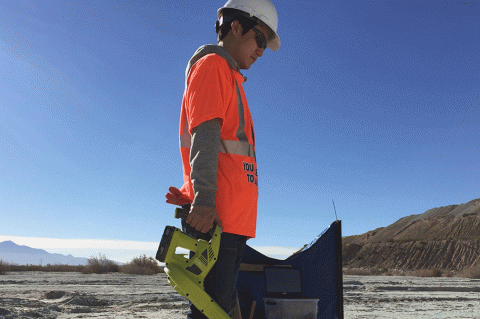 Taehee Lee applies a blower to the desert dirt.