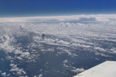 A photo of the top of the cloud layer, taken from a plane. The wing of the plane is visible in the bottom right of the photo.