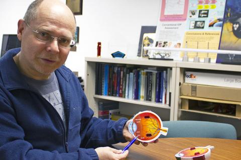 Wolfgang Fink holds a schematic of an eyeball
