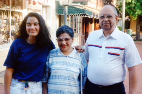 Three people -- an adult daughter and her parents -- smile for a photo.