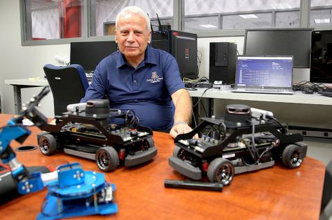 Salim Hariri in his lab with autonomous vehicles