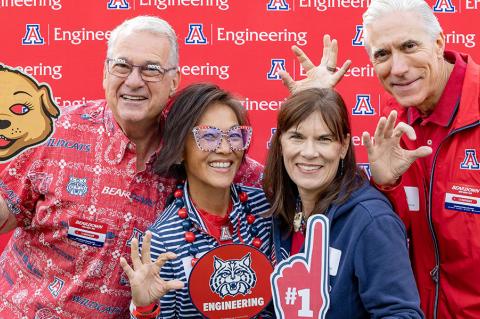 four people in front of a photo backdrop