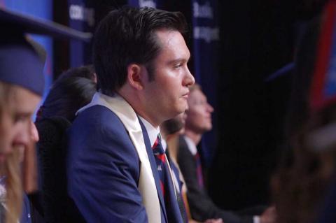 Profile photo of Jeffrey Bristol, sitting in a blue suit and graduation sash, looking straight ahead.