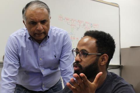 Two people speak in a classroom