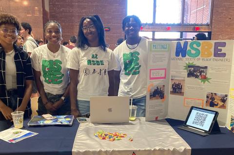 Four students pose for a photo at a student event.