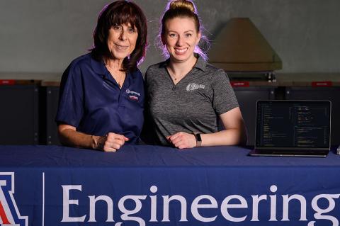 Sharon ONeal and Juliana Lincoln stand at a table with a laptop