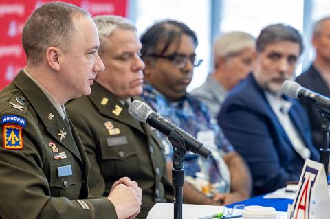 conference panelists sit at a table