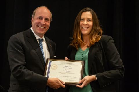 Erin Ratcliff receives a framed certificate from Department of Energy Under Secretary for Science Paul Dabber