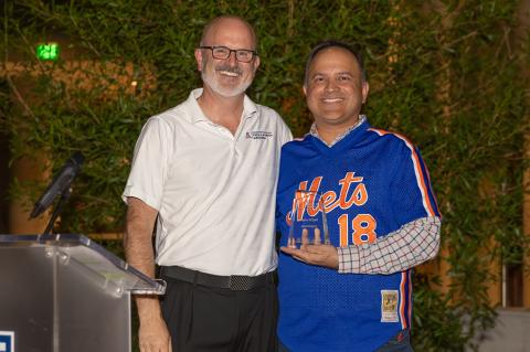 Two men stand at a podium with an award