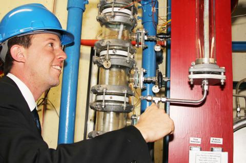 man inspecting water pipes