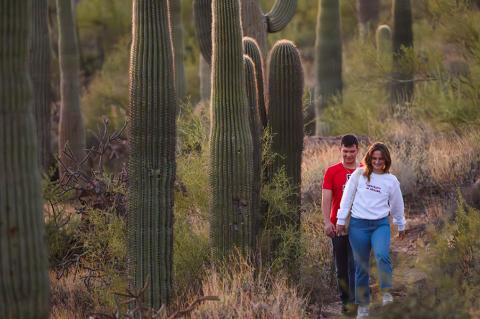 two University of Arizona students walk through a desert landscape