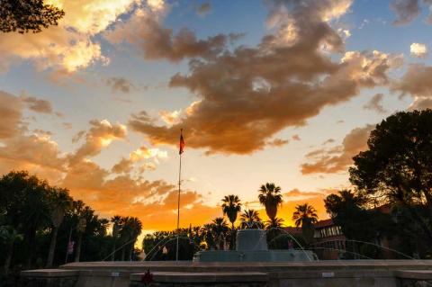 The sun sets over a fountain on the UA campus.
