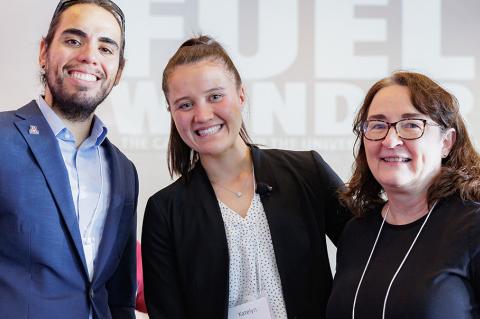 Three people pose indoors