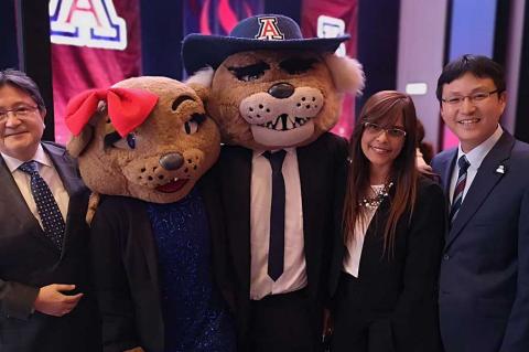 Two men and a woman pose for a photo with Wilma and Wilbur Wildcat