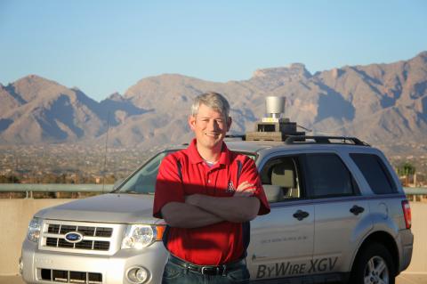 Jonathan Sprinkle in front of the CAT Vehicle